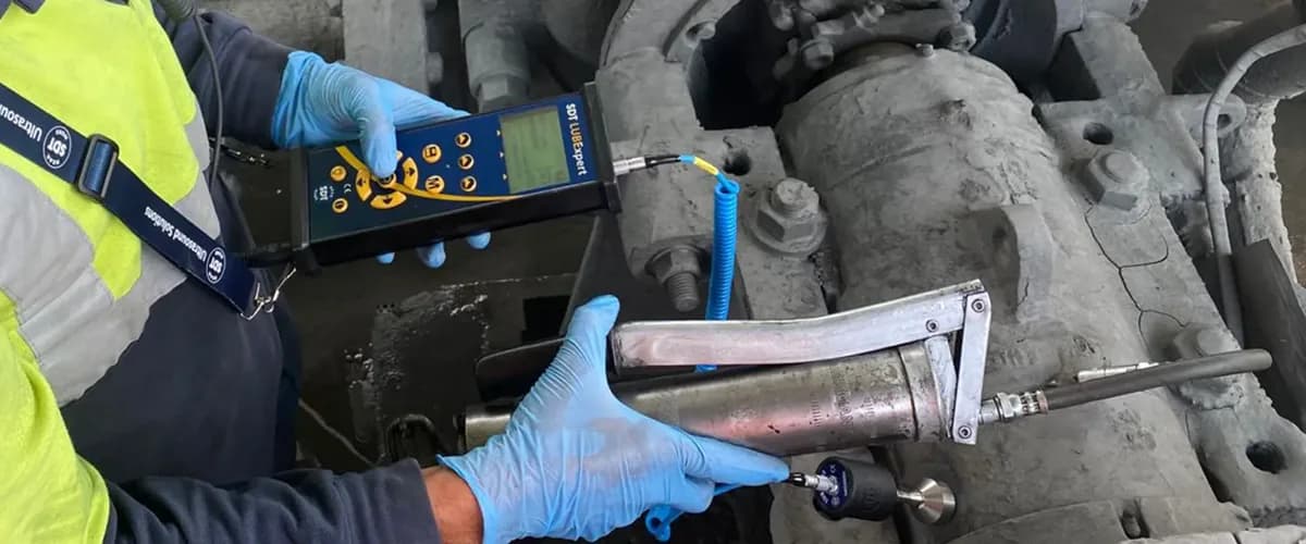 LUBExpert with the LUBESense1 sensor on a grease gun: the technician adds grease in half-shots and watches friction on screen. Photo: SDT Ultrasound Solutions