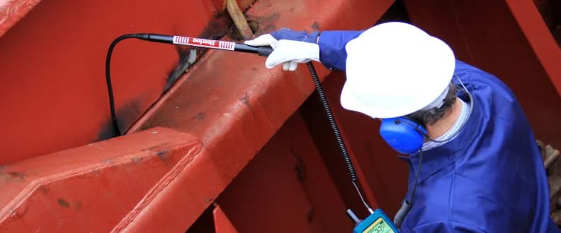 Testing a cargo hatch for tightness: an ultrasonic transmitter inside, the operator runs a flexible SDT sensor along the seal outside. Photo: SDT Ultrasound Solutions